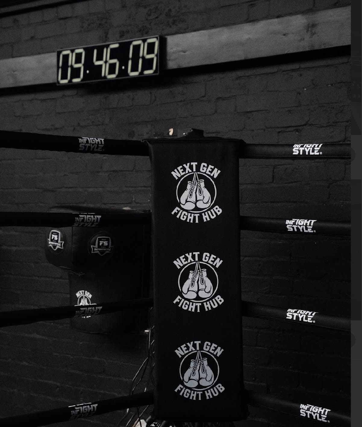 A padded ring corner and the round timer on the wall