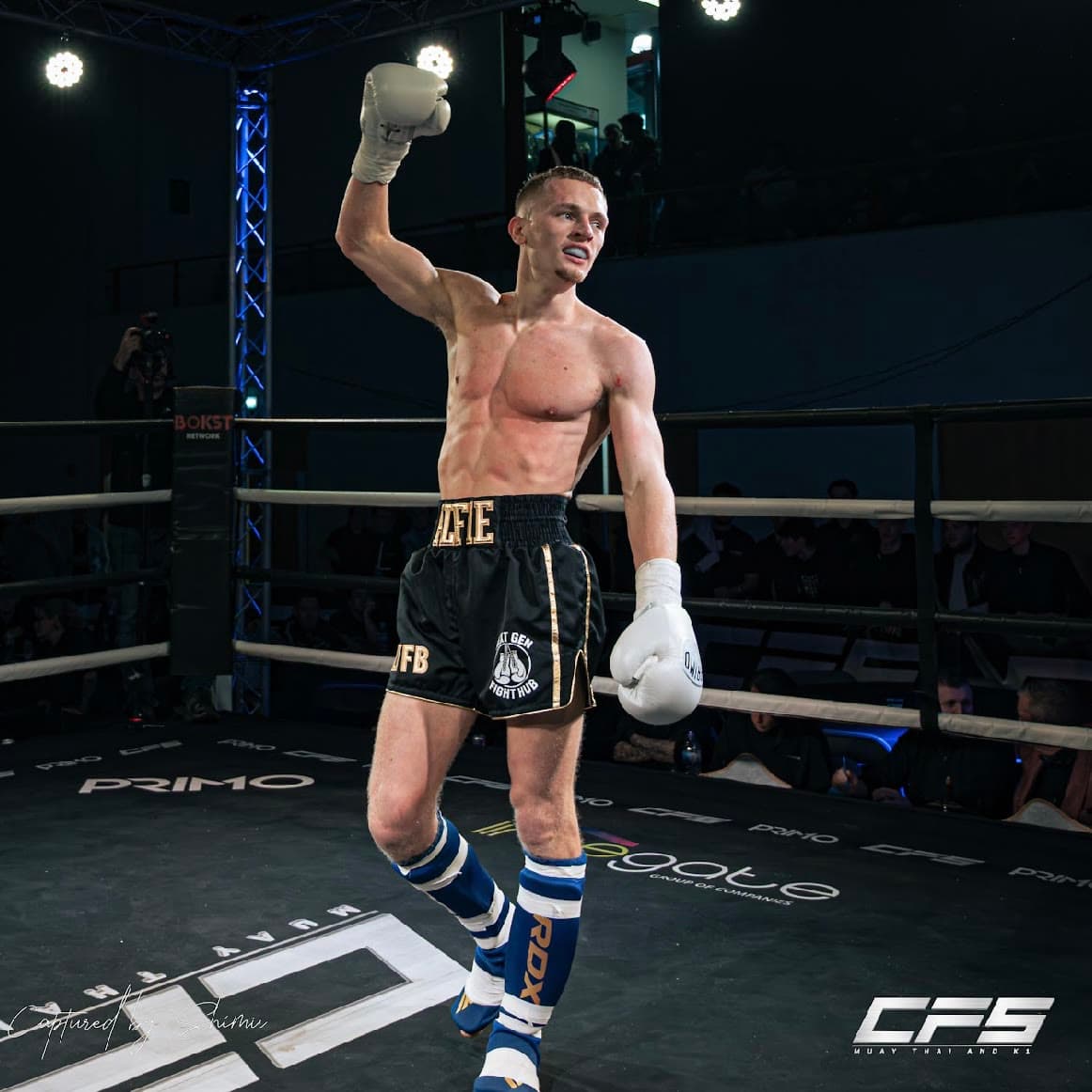 A Next Gen fighter celebrating in the ring with his arm raised