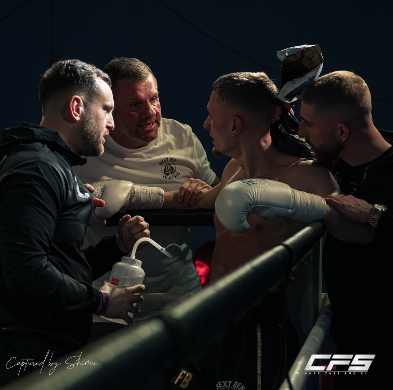 The corner team working on a Next Gen fighter between rounds