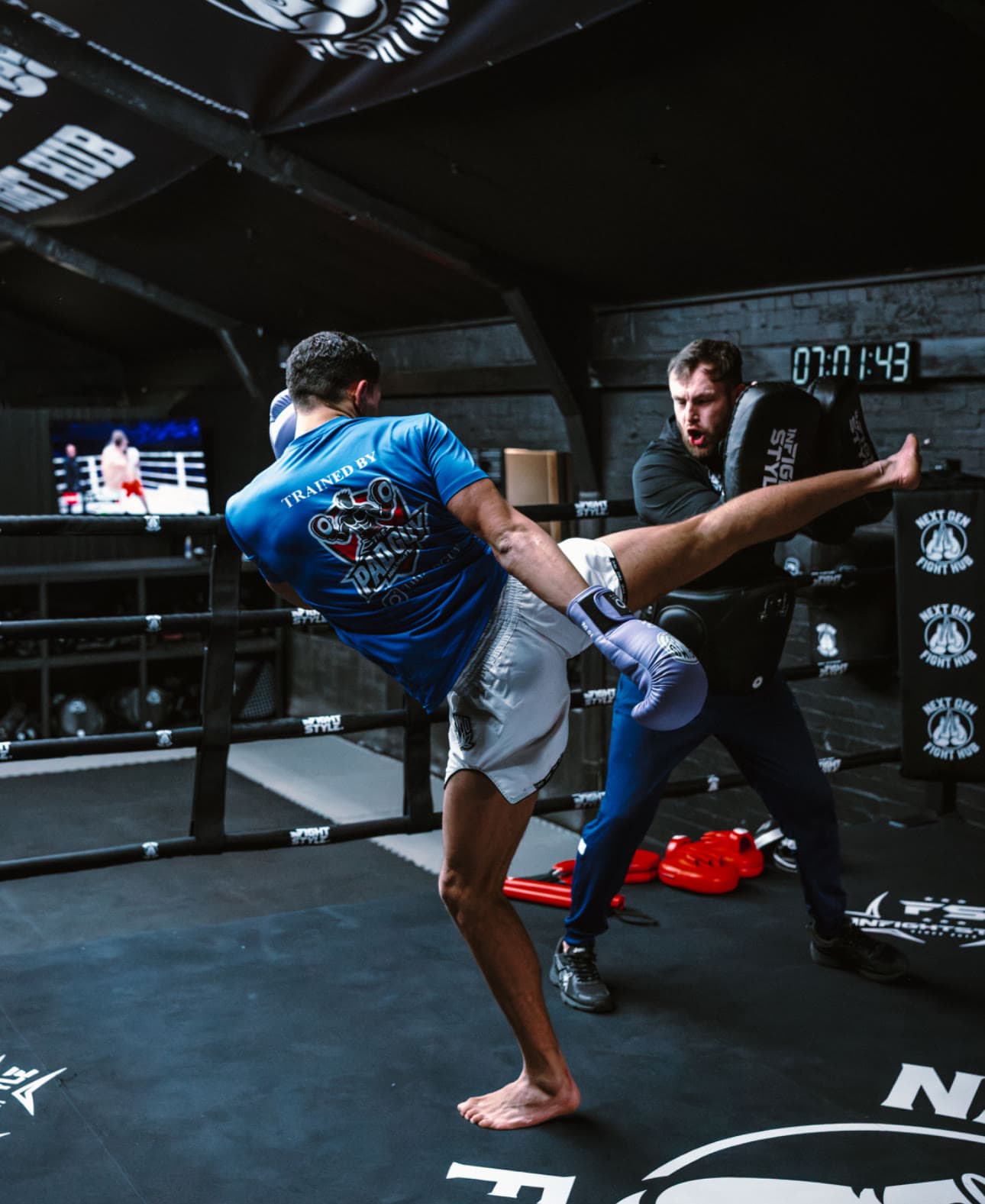 A member landing a body kick on the pads during a session