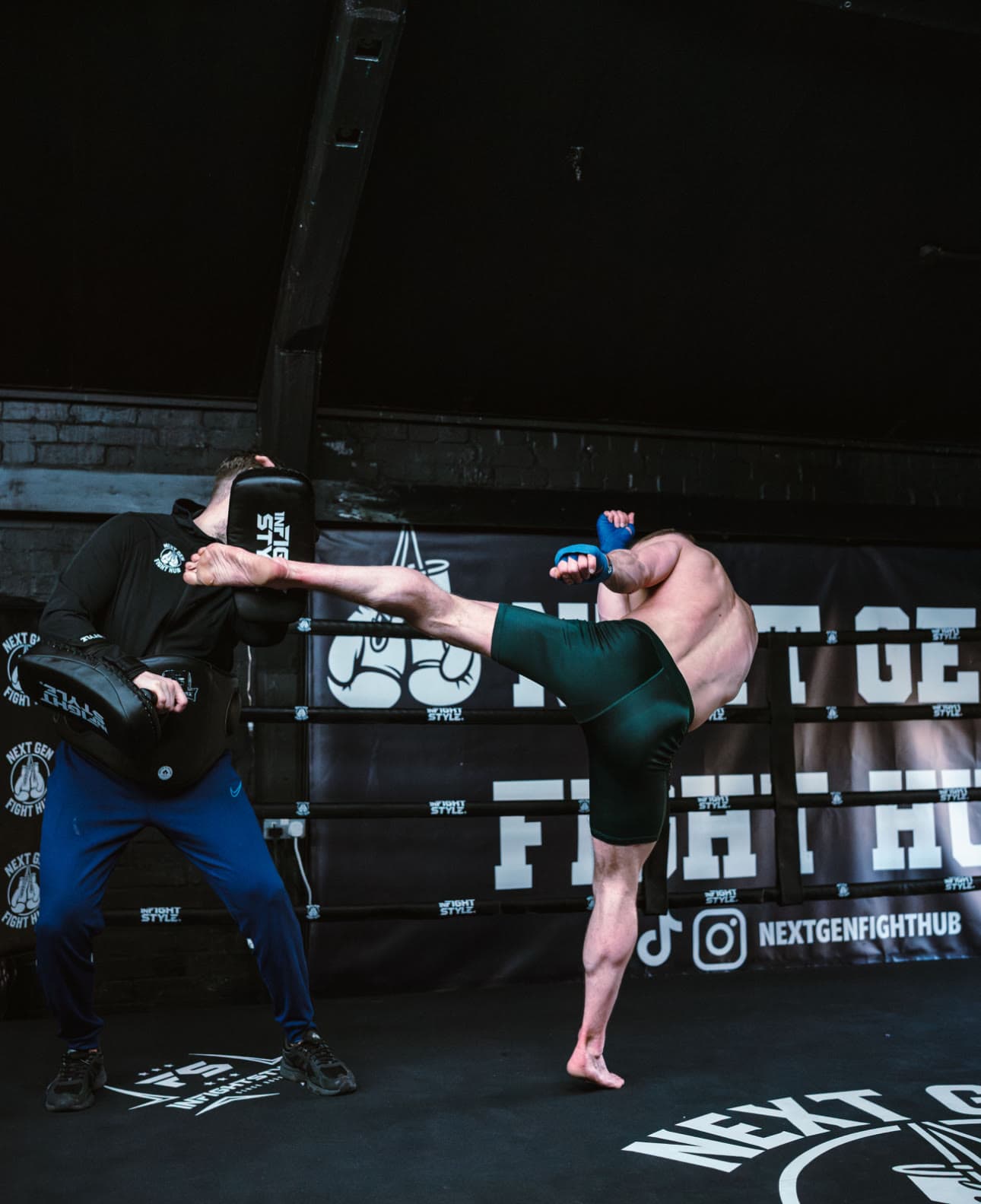 A member kicking the pads during an adult Muay Thai session