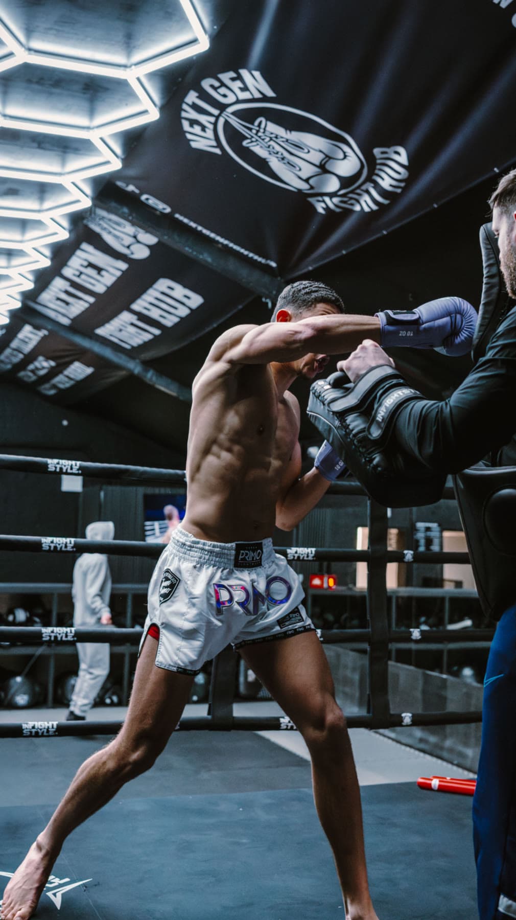 A fighter driving a straight punch into the pads