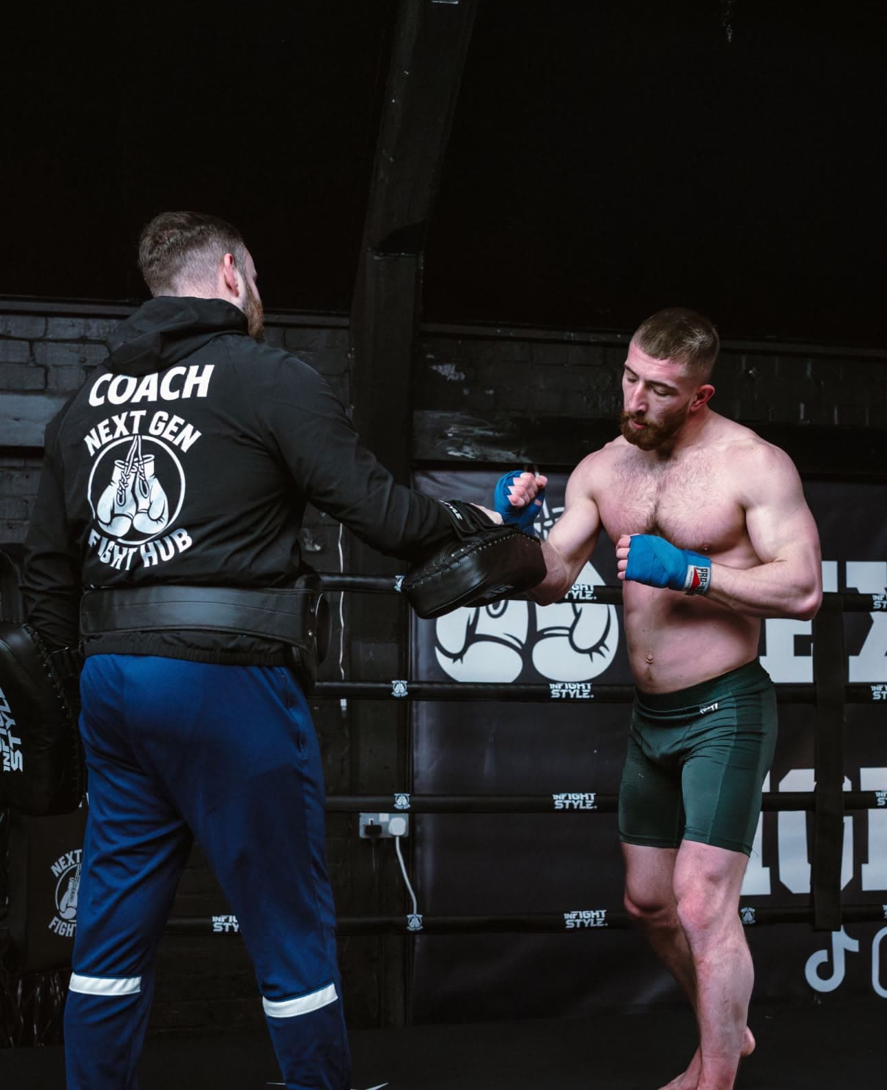 Head coach Hayden on the mitts in the ring in his Next Gen coach jacket